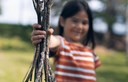 young girl holding a bundle of tree branches