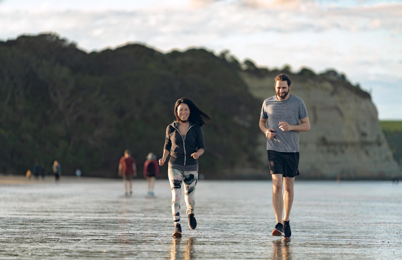 young couple running at the beach