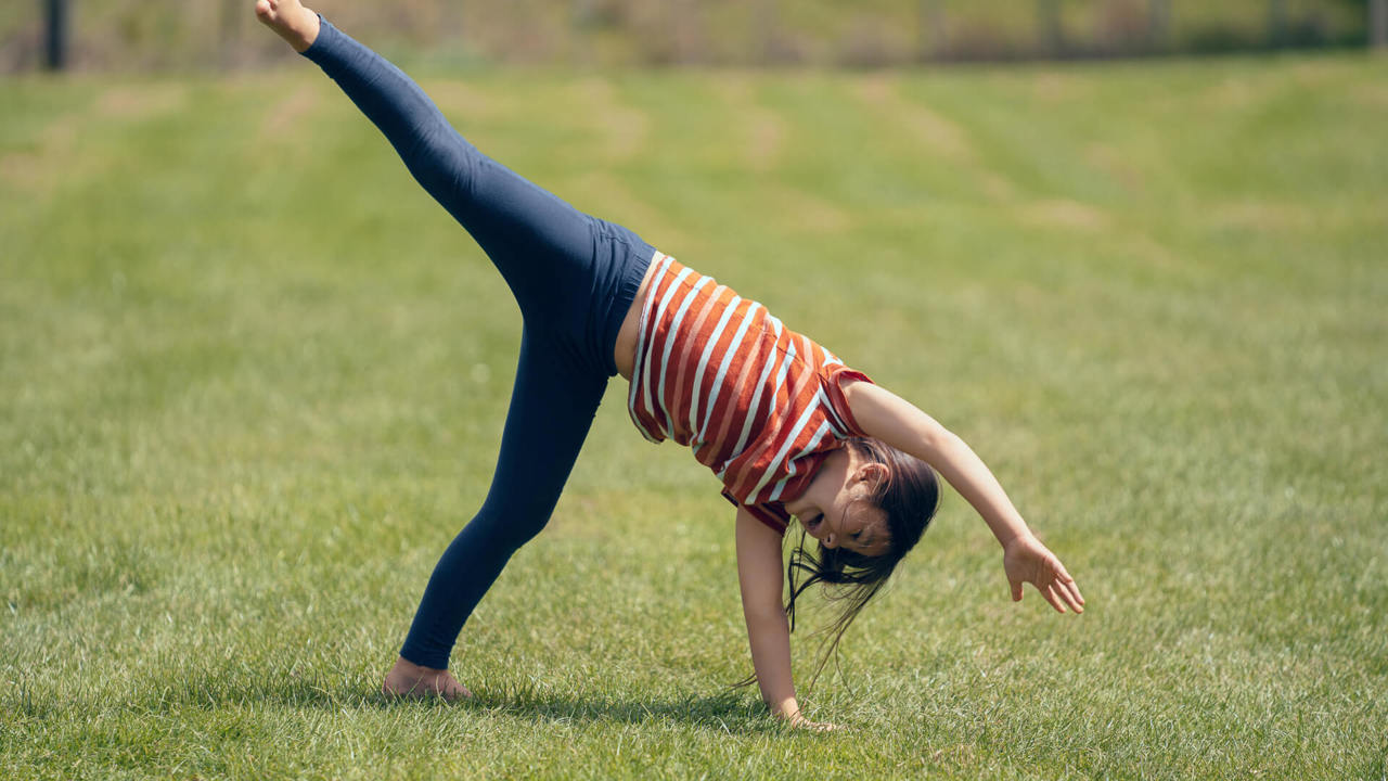 young girl doing aerial in the garden