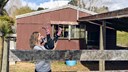 young mum playing with daughter - house in background