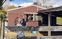 young mum playing with daughter - house in background