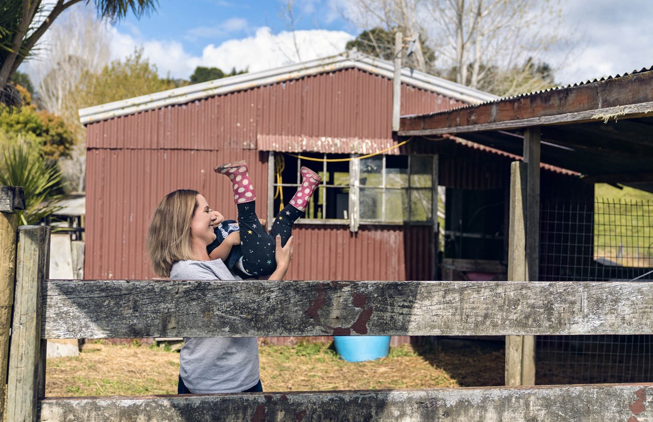 young mum playing with daughter - house in background young mum playing with daughter - house in background