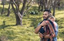 young dad holding sleeping daughter in the park