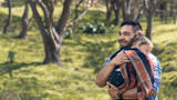 young dad holding sleeping daughter in the park