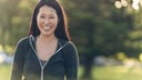 smiling asian girl in the park - front view