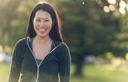 smiling asian girl in the park - front view