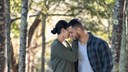 young couple holding each other in the forest