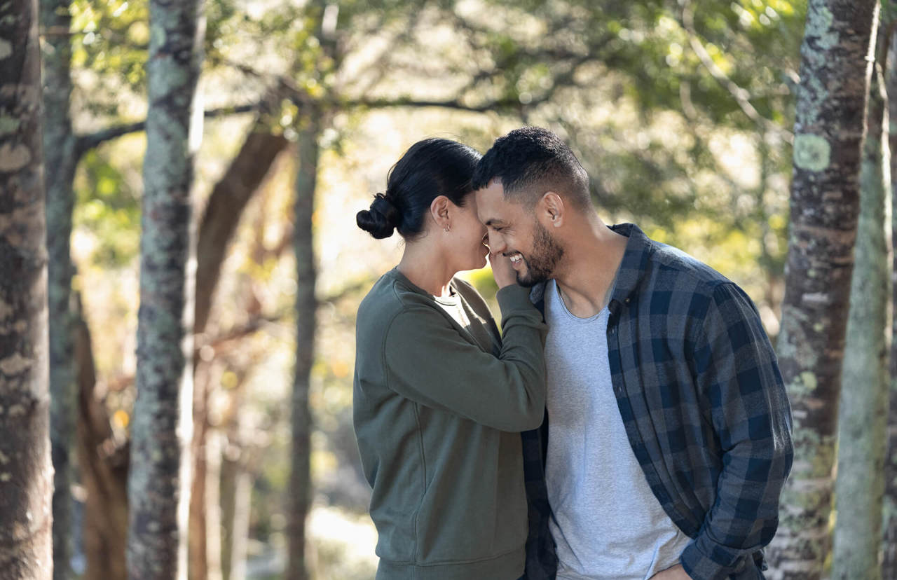 young couple holding each other in the forest