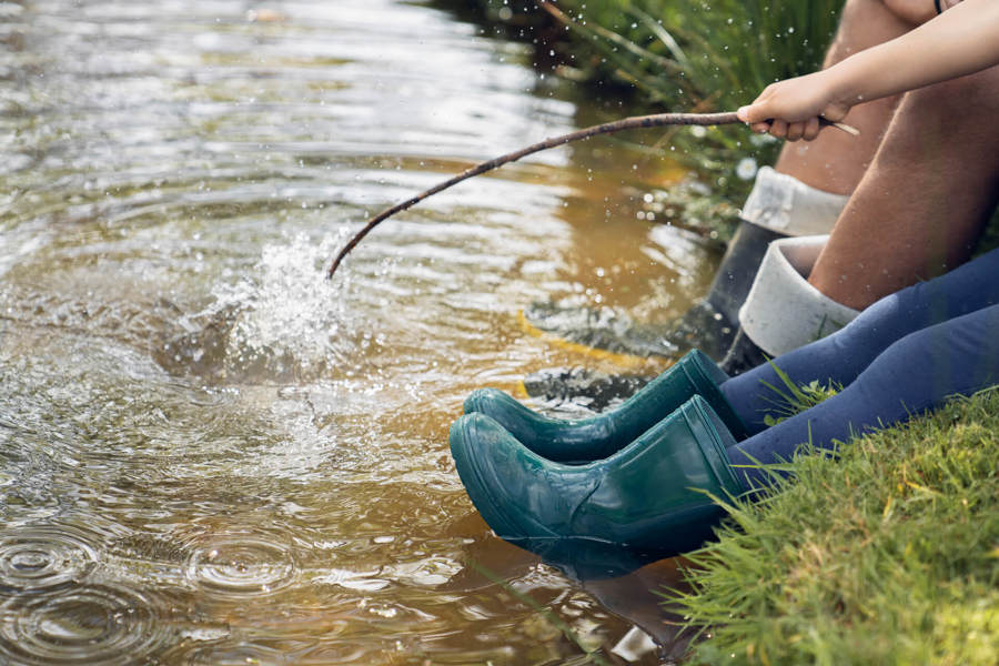 2 children playing in water stream - legs only showing Fidelity Life solvency.